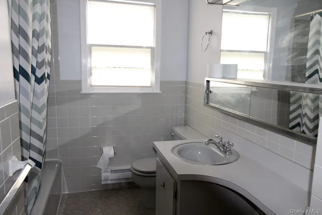 a bathroom with a sink a toilet and a window