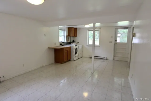 an empty room with windows and cabinet