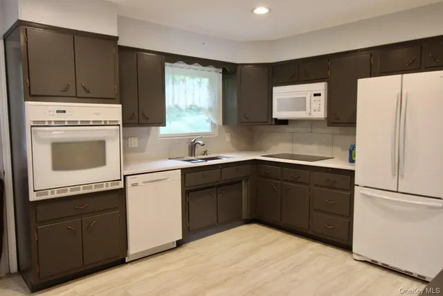 a kitchen with a refrigerator sink and cabinets