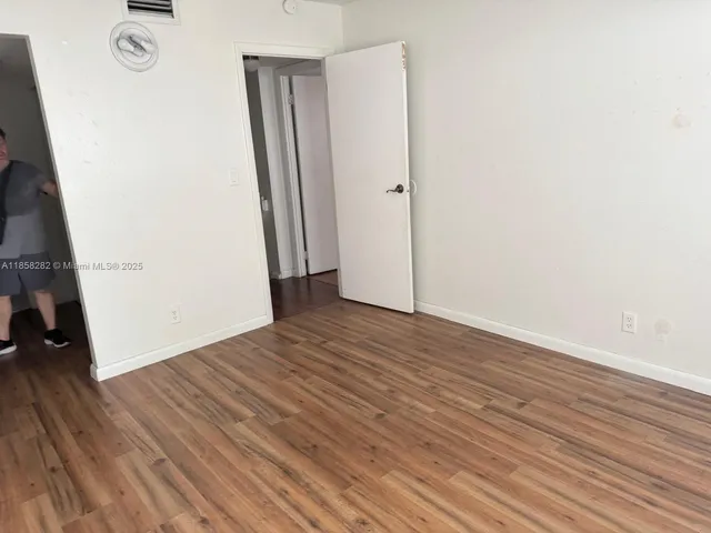 an empty room with wooden floor and closet