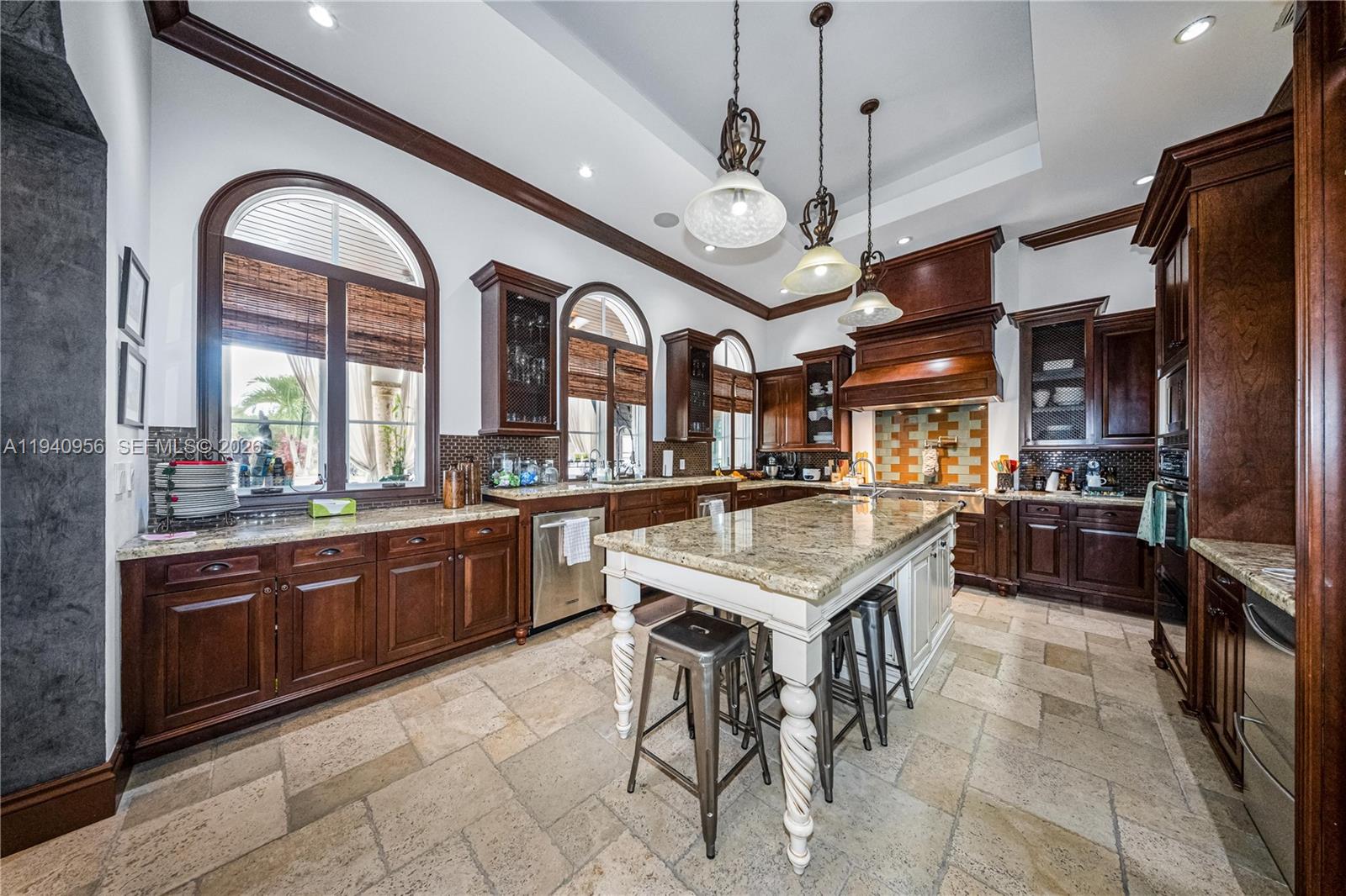 7538 Southwest 64th Street Miami, FL 33143 - Photo 14 of 78 a large kitchen with stainless steel appliances granite countertop a stove a sink a dining table and chairs with wooden floor