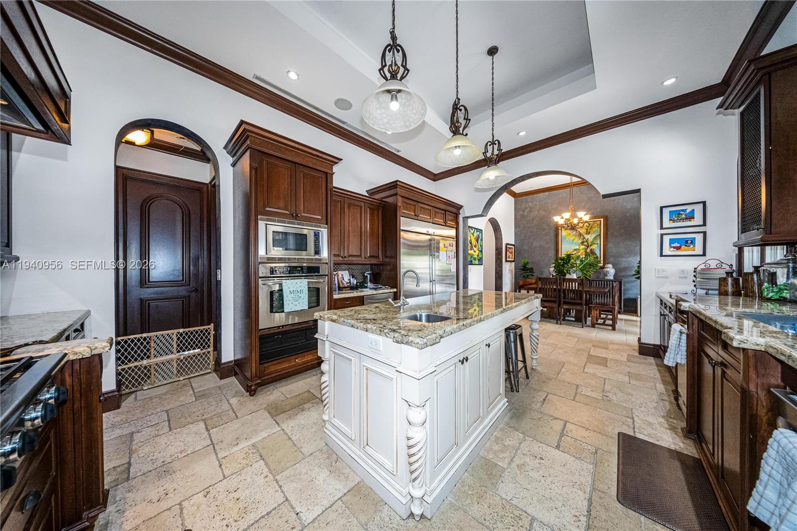 7538 Southwest 64th Street Miami, FL 33143 - Photo 16 of 78 a kitchen with stainless steel appliances granite countertop center island wooden cabinets and stove top oven