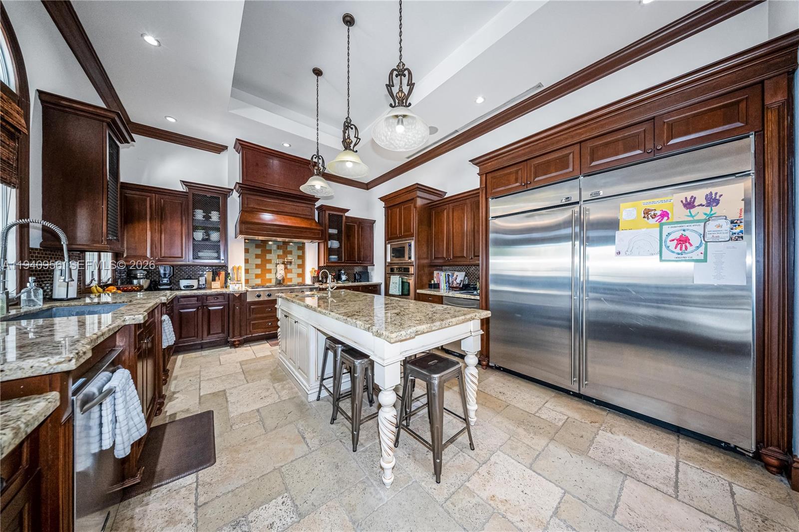 7538 Southwest 64th Street Miami, FL 33143 - Photo 17 of 78 a kitchen with stainless steel appliances granite countertop a stove kitchen island a refrigerator and couches with wooden floor