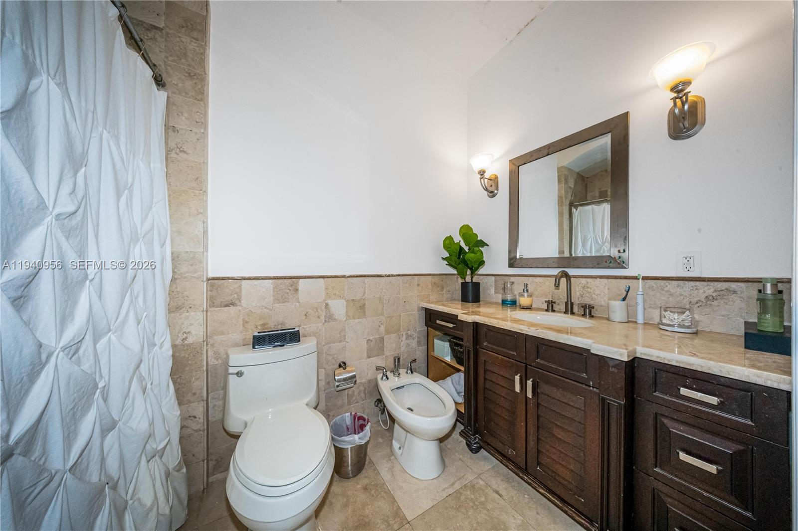 7538 Southwest 64th Street Miami, FL 33143 - Photo 39 of 78 a bathroom with a toilet a sink and mirror
