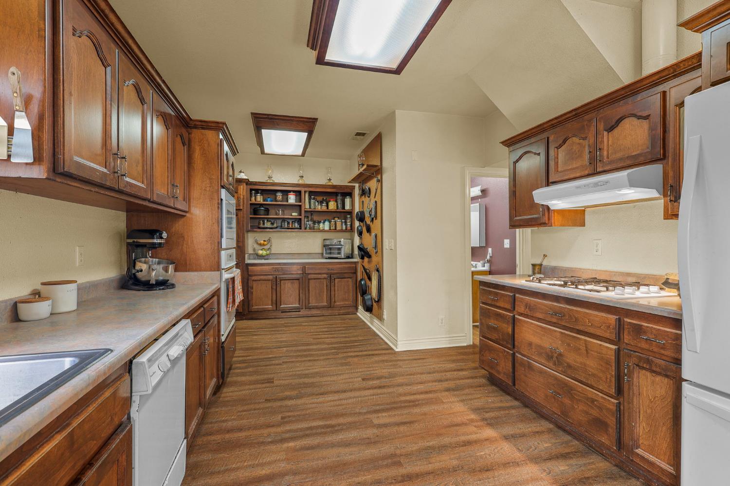 18525 Emerson Road Red Bluff, CA 96080 - Photo 19 of 92 a kitchen with stainless steel appliances granite countertop a refrigerator a stove and a wooden floors