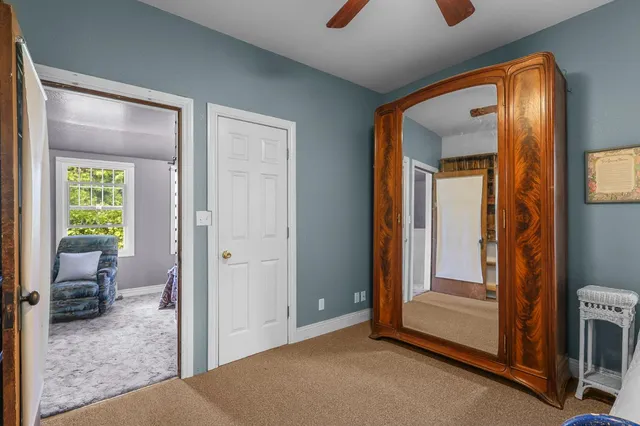 a view of an empty room with furniture and a window