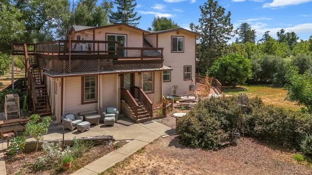 a aerial view of a house with a small yard and large trees