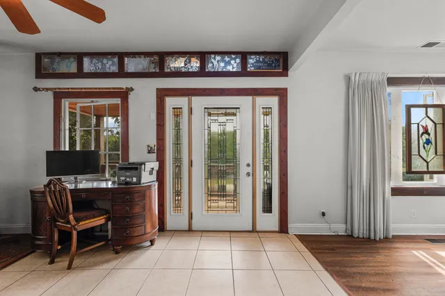 a dining room with furniture a rug a potted plant and wooden floor