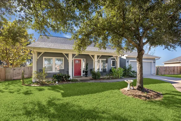 a front view of a house with a yard and trees