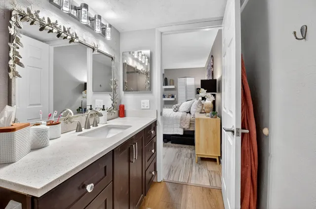 a bathroom with a granite countertop sink toilet and shower glass cabinet