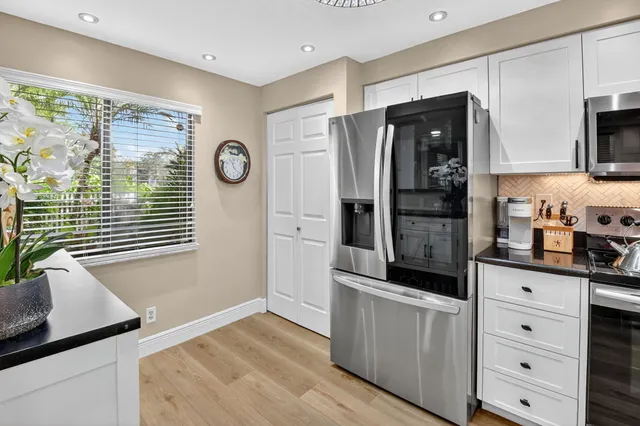 a kitchen with stainless steel appliances granite countertop a refrigerator and a stove top oven