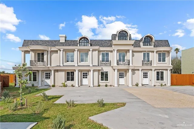 a front view of a residential apartment building with a yard