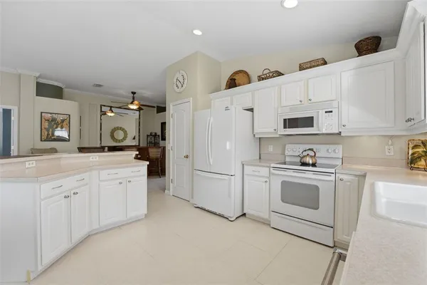 a kitchen with white cabinets and white appliances