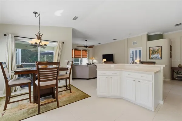 a kitchen with stainless steel appliances kitchen island granite countertop a table chairs and a refrigerator