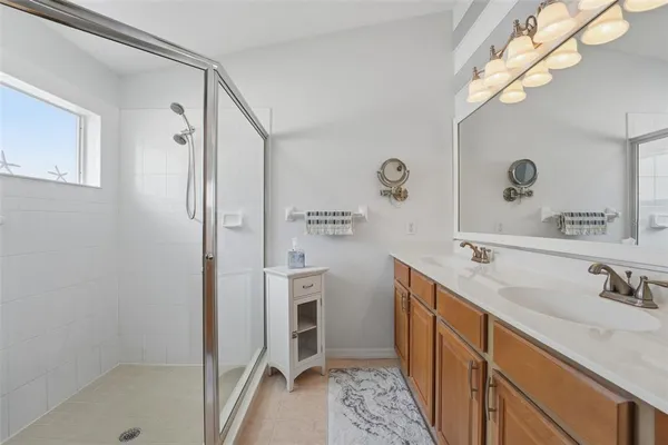 a bathroom with a double vanity sink mirror and shower