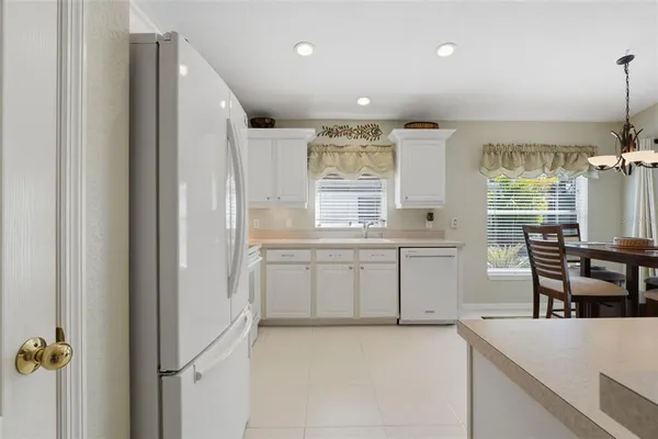 a kitchen with a refrigerator and table chairs