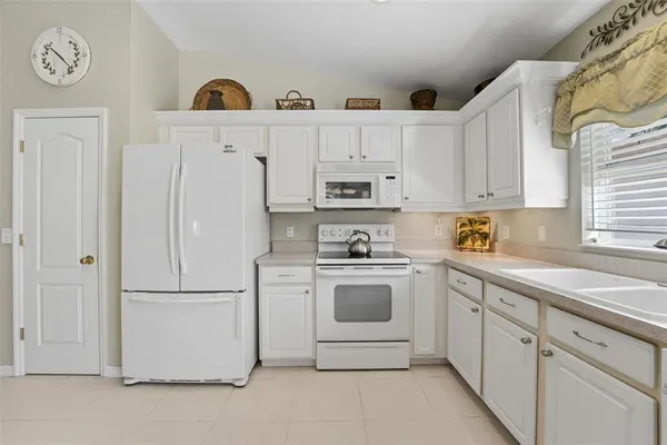 a kitchen with cabinets stainless steel appliances and a window