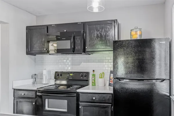 a kitchen with a refrigerator and a stove top oven