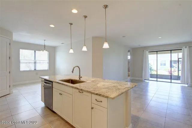 a kitchen with a sink granite counter tops and a wooden floor