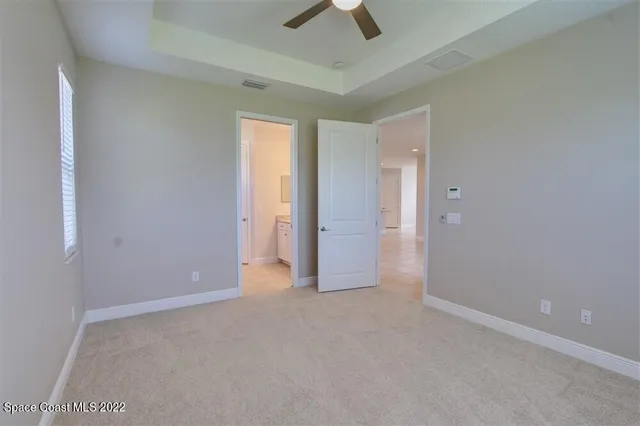 an empty room with chandelier fan