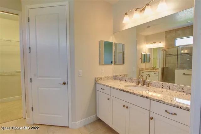 a bathroom with a granite countertop sink mirror and double