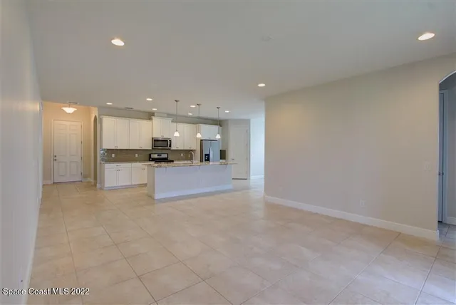 a view of kitchen with kitchen island white cabinets and refrigerator