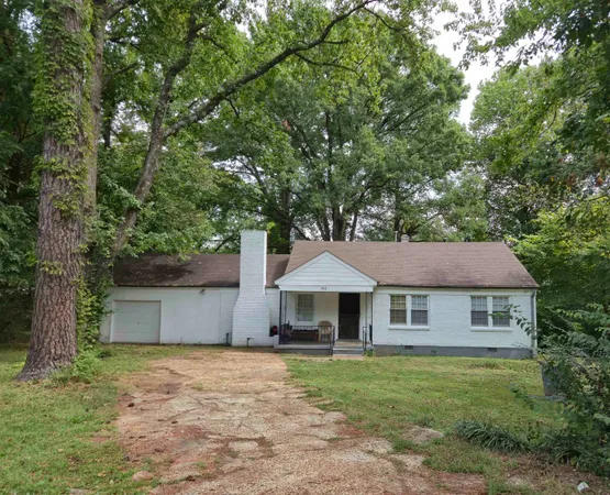 a front view of a house with a garden and tree