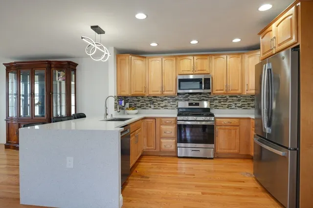 a kitchen with granite countertop a stove top oven a sink and a refrigerator