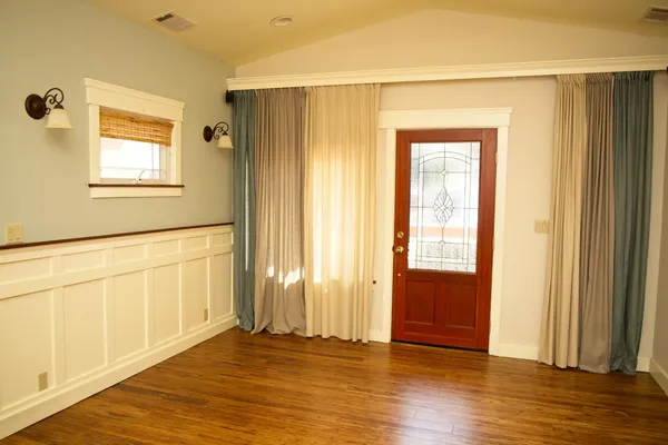 a kitchen with stainless steel appliances granite countertop a refrigerator a stove and a dining table with wooden floor