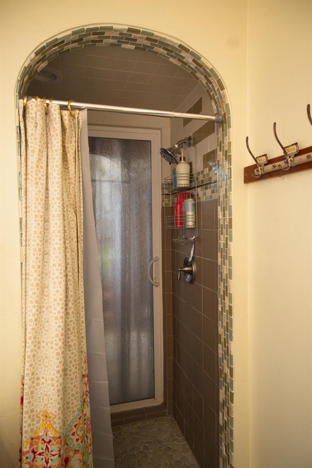 126 Center Street Jackson, CA 95642 - Photo 52 of 95 Custom arched access to dual head shower, seating and exterior vinyl sliding door. Don't you want to add a hot tub on the private covered patio area off primary bed/bath?!