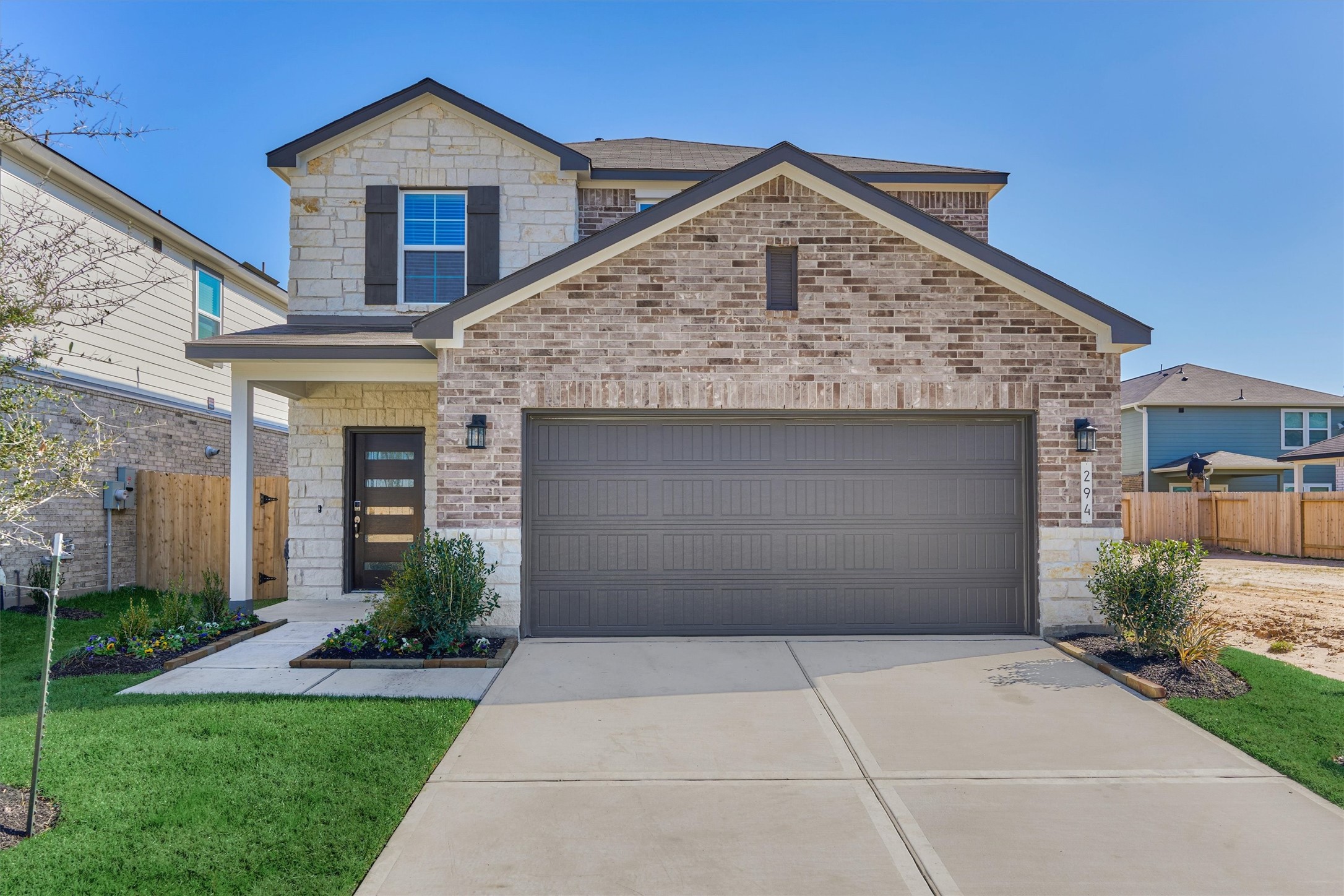 a front view of a house with a garden and plants