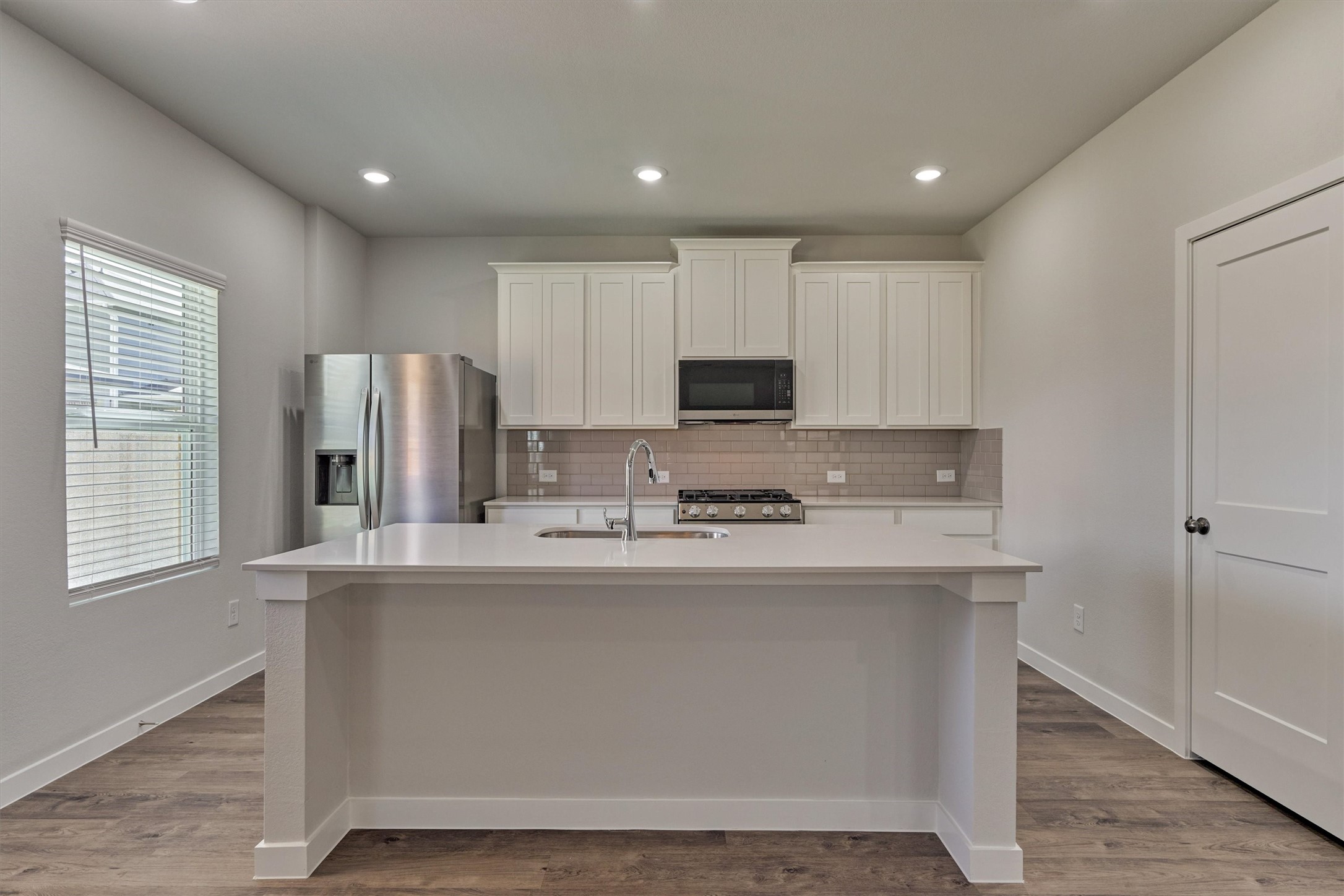 294 Brazen Forest Trail Magnolia, TX 77354 - Photo 14 of 37 a kitchen with stainless steel appliances granite countertop a refrigerator a stove a sink and white cabinets with wooden floor