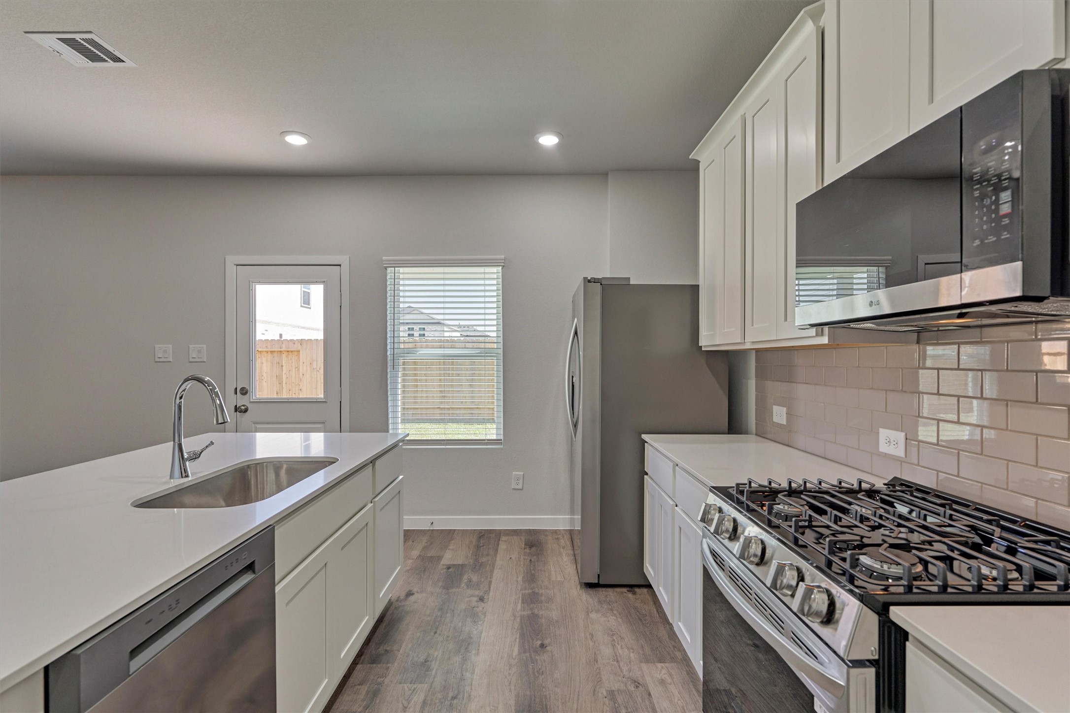 294 Brazen Forest Trail Magnolia, TX 77354 - Photo 16 of 37 a kitchen with granite countertop a sink stove and refrigerator