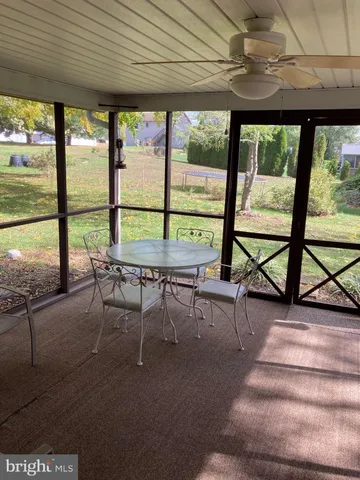 a view of a patio with table and chairs floor to ceiling window with wooden floor