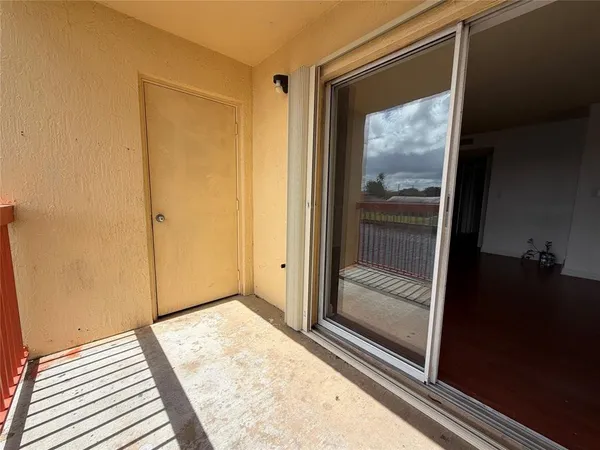 a view of a room that has a large window and front door