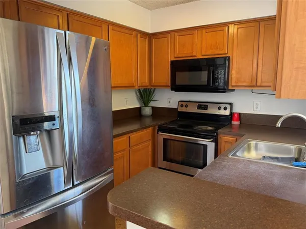 a kitchen with stainless steel appliances granite countertop a refrigerator stove and microwave