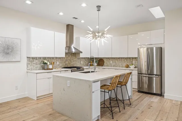 a kitchen with kitchen island a sink stove and refrigerator