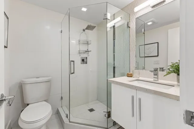 a bathroom with a sink toilet vanity and shower