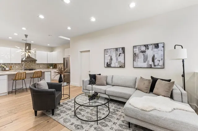 a living room with furniture kitchen view and a table