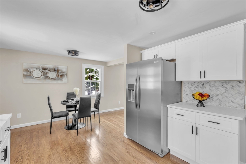 9 Edwill Road East Longmeadow, MA 01028 - Photo 12 of 34 a kitchen with stainless steel appliances granite countertop a refrigerator a stove a dining table and chairs with wooden floor