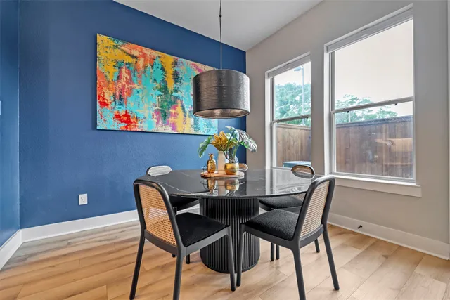 a view of a dining room with furniture a chandelier and wooden floor