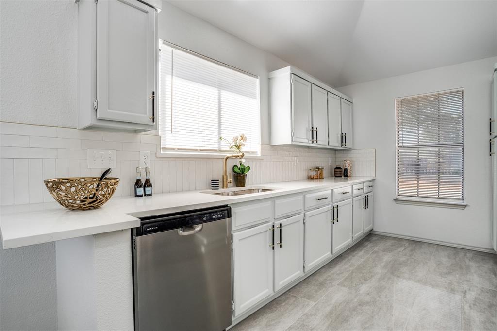 509 Rose Drive Allen, TX 75002 - Photo 12 of 25 a kitchen with a sink stove and cabinets