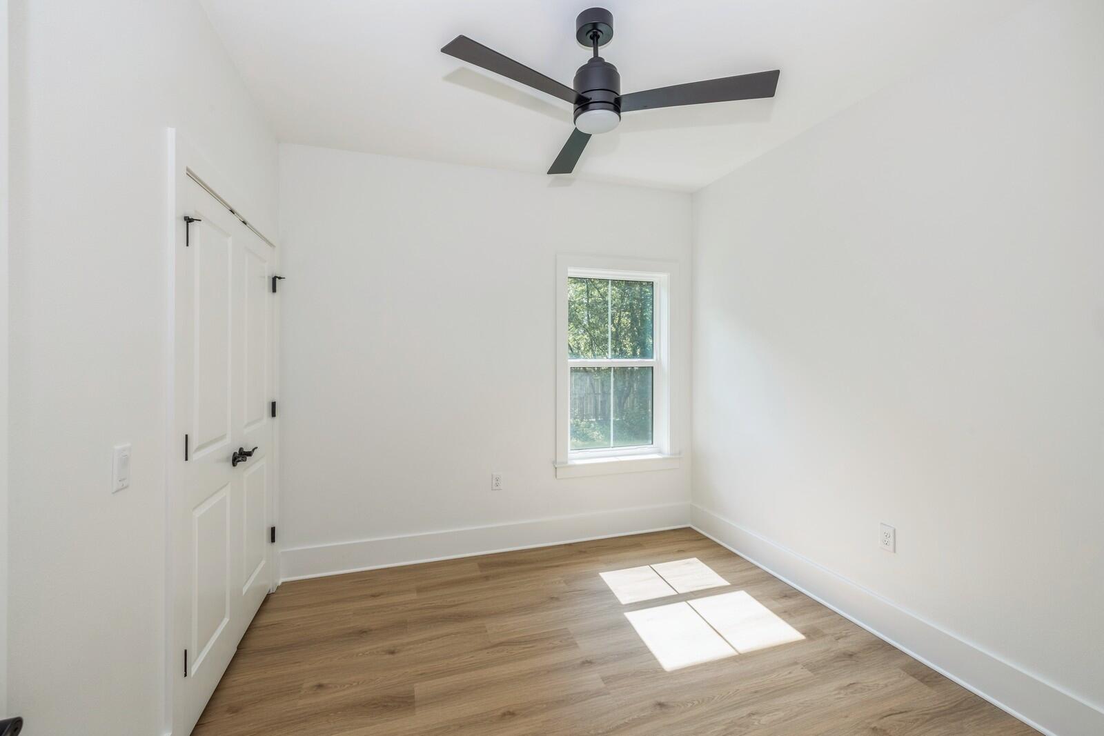 521 Brock Avenue Crestview, FL 32539 - Photo 12 of 16 an empty room with wooden floor fan and windows