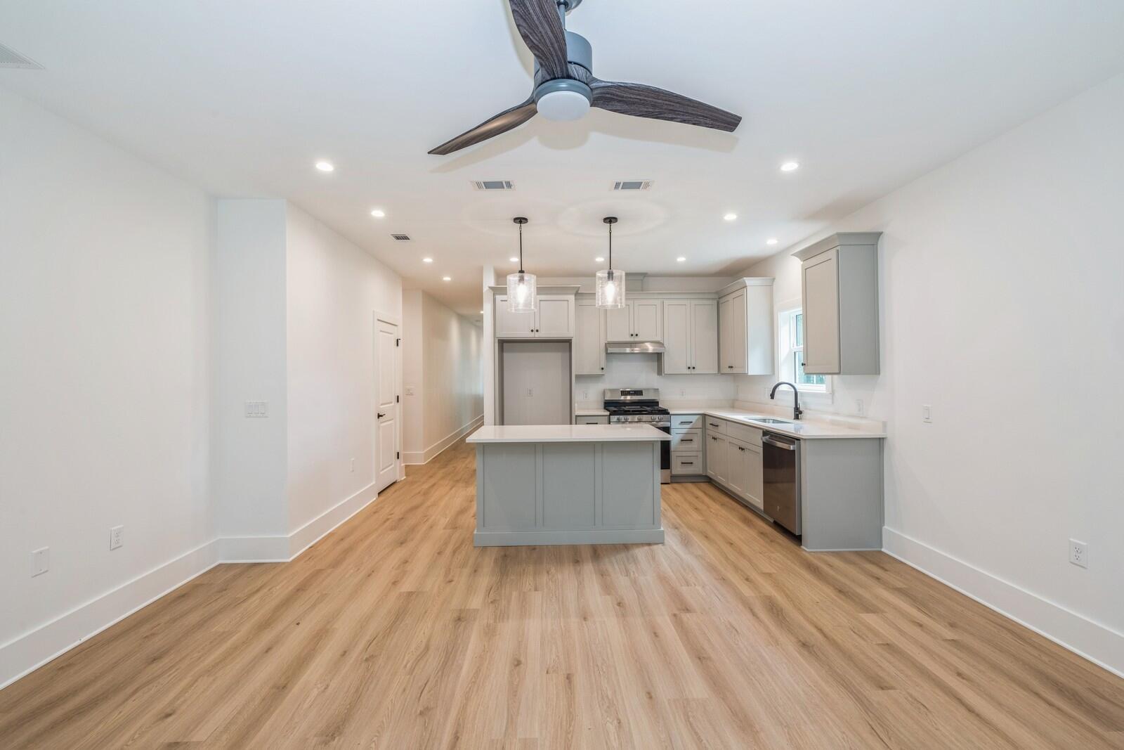 521 Brock Avenue Crestview, FL 32539 - Photo 3 of 16 a large kitchen with a wooden floor and stainless steel appliances