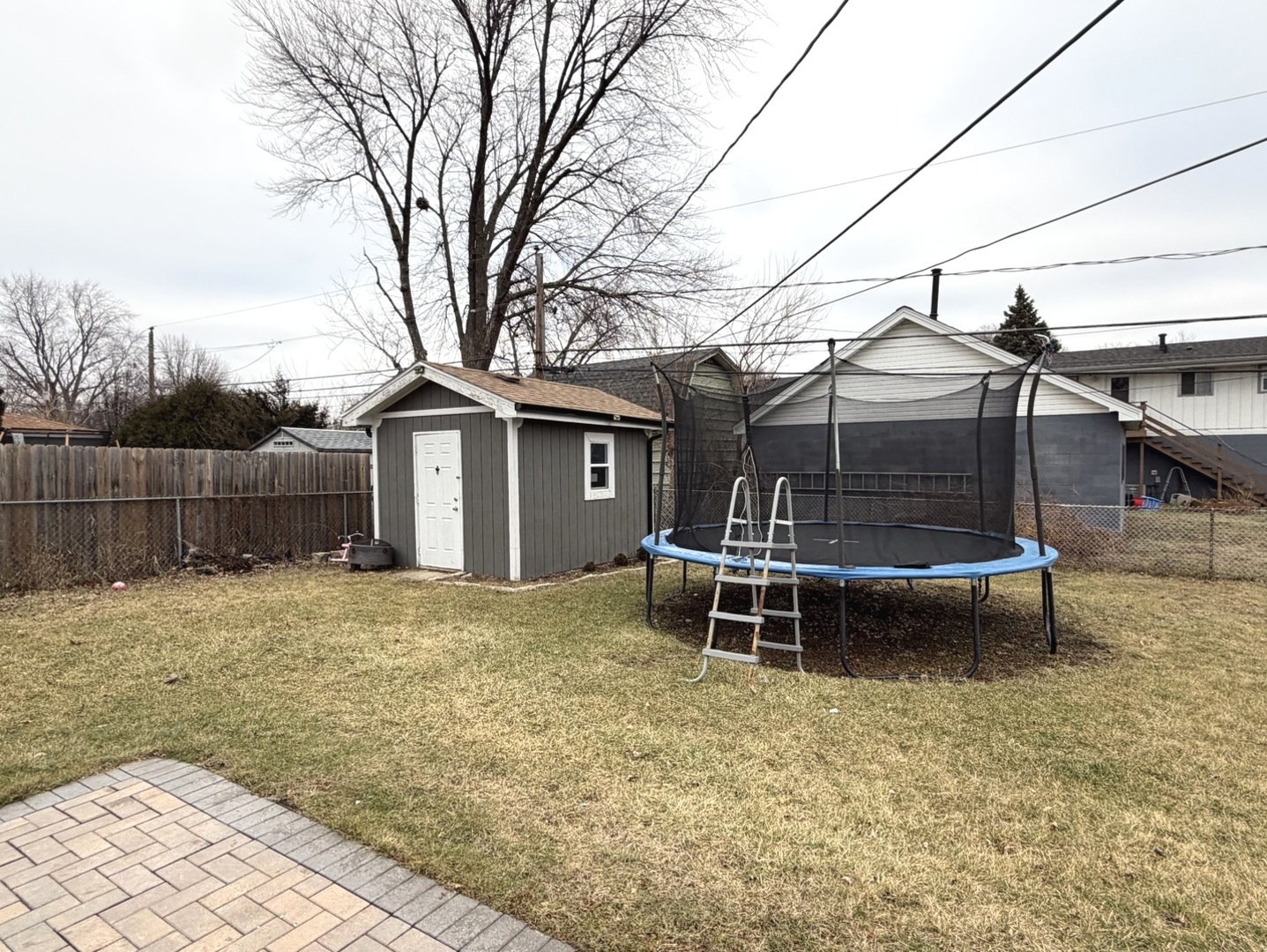 709 Hudson Avenue Romeoville, IL 60446 - Photo 5 of 16 a backyard of a house with wooden fence and large trees