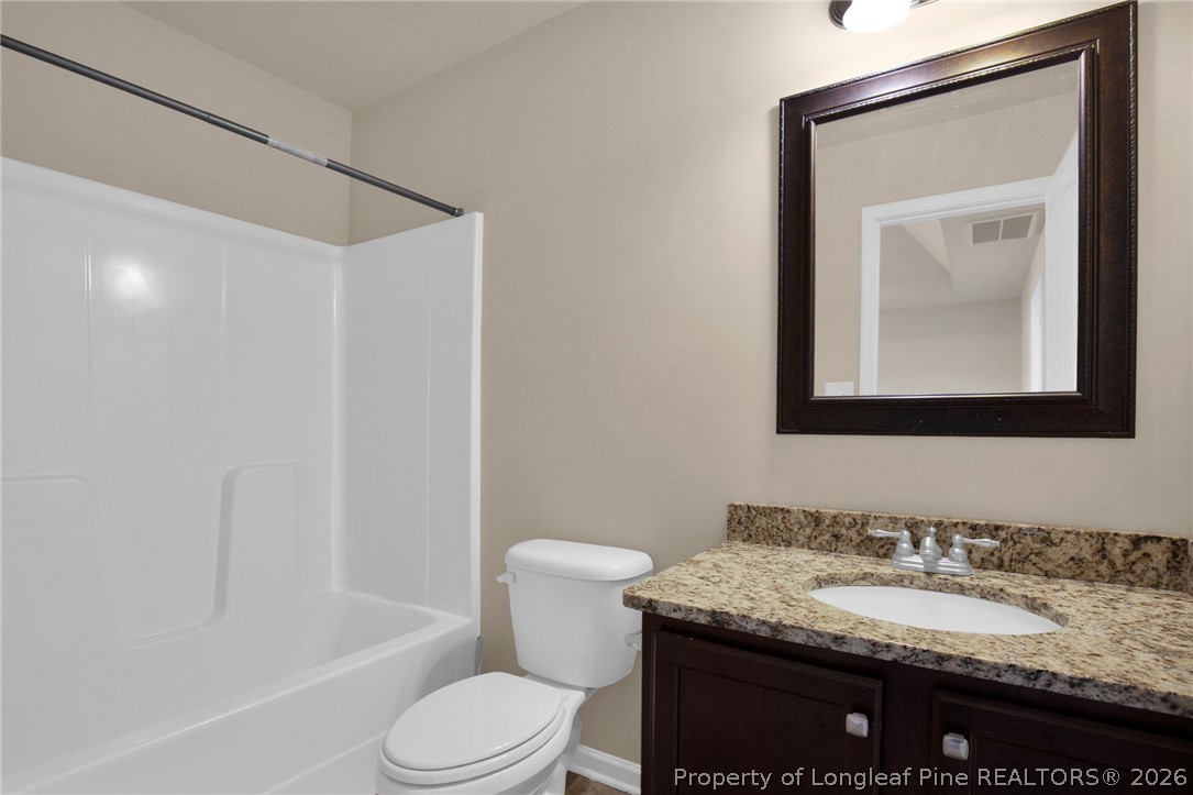 2145 Harrington Road Fayetteville, NC 28306 - Photo 37 of 50 a bathroom with a granite countertop toilet sink and mirror