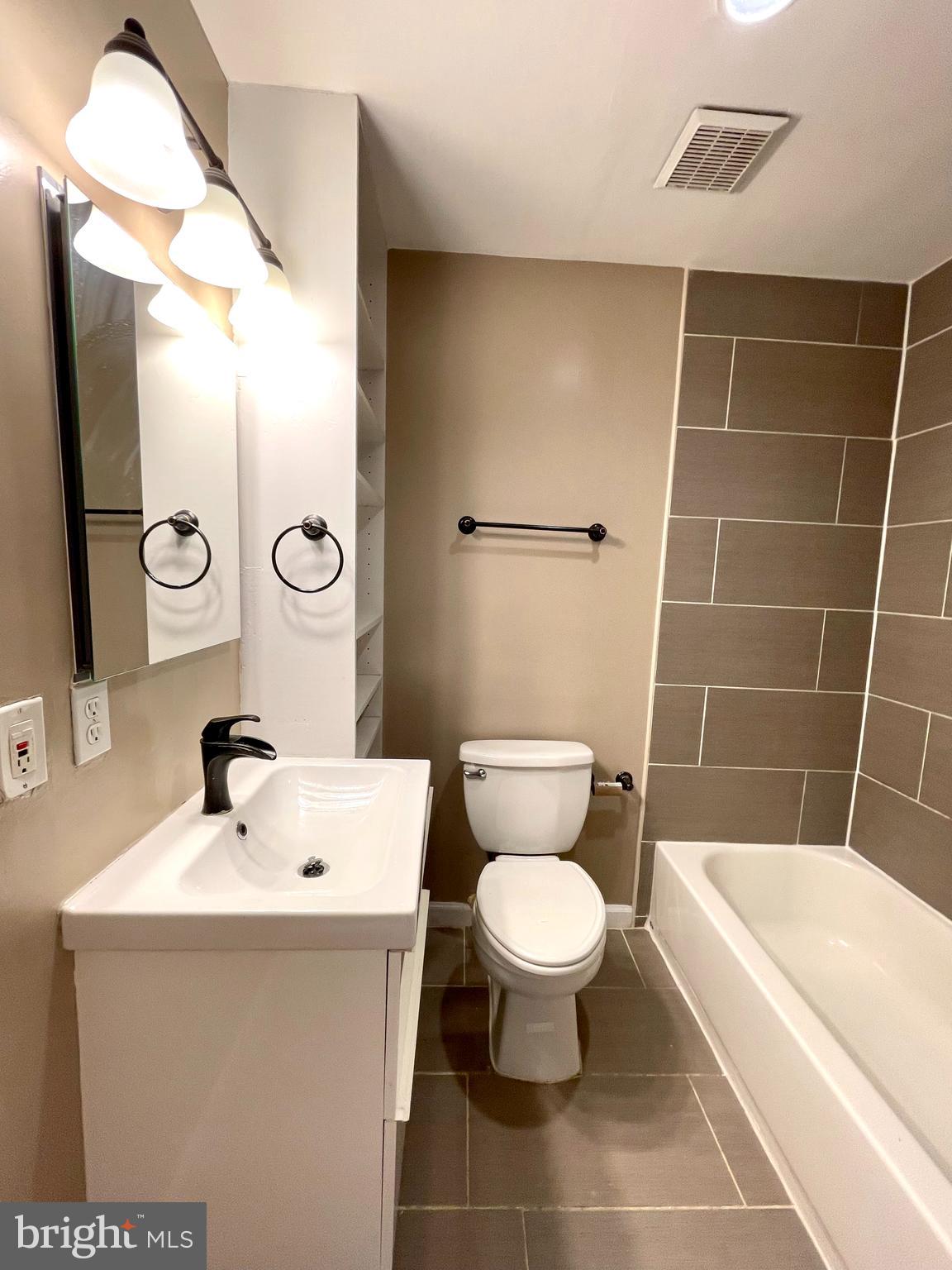 819 12th Street Northeast, Unit 1 Washington, DC 20002 - Photo 11 of 11 a bathroom with a sink toilet a mirror and bathtub