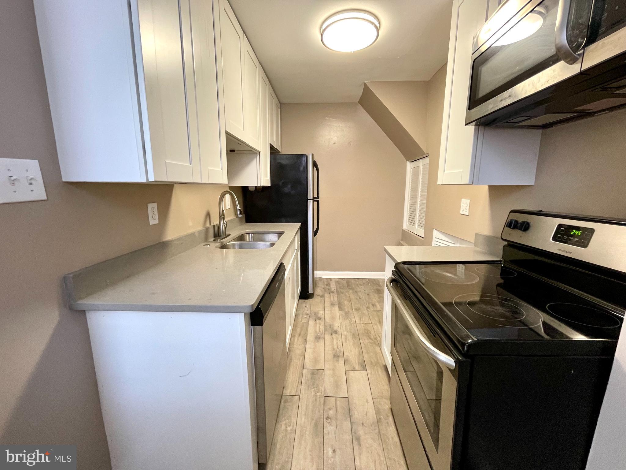 819 12th Street Northeast, Unit 1 Washington, DC 20002 - Photo 6 of 11 a kitchen with a sink a stove and cabinets