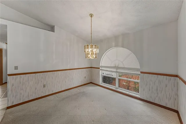 an empty room with a ceiling fan and a window