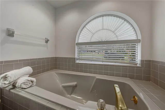 an empty room with wooden floor fireplace and windows